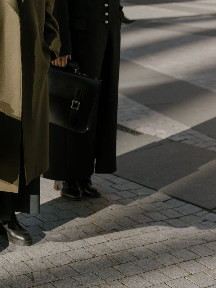 Two lawyers with briefcases on a sunlit pavement
