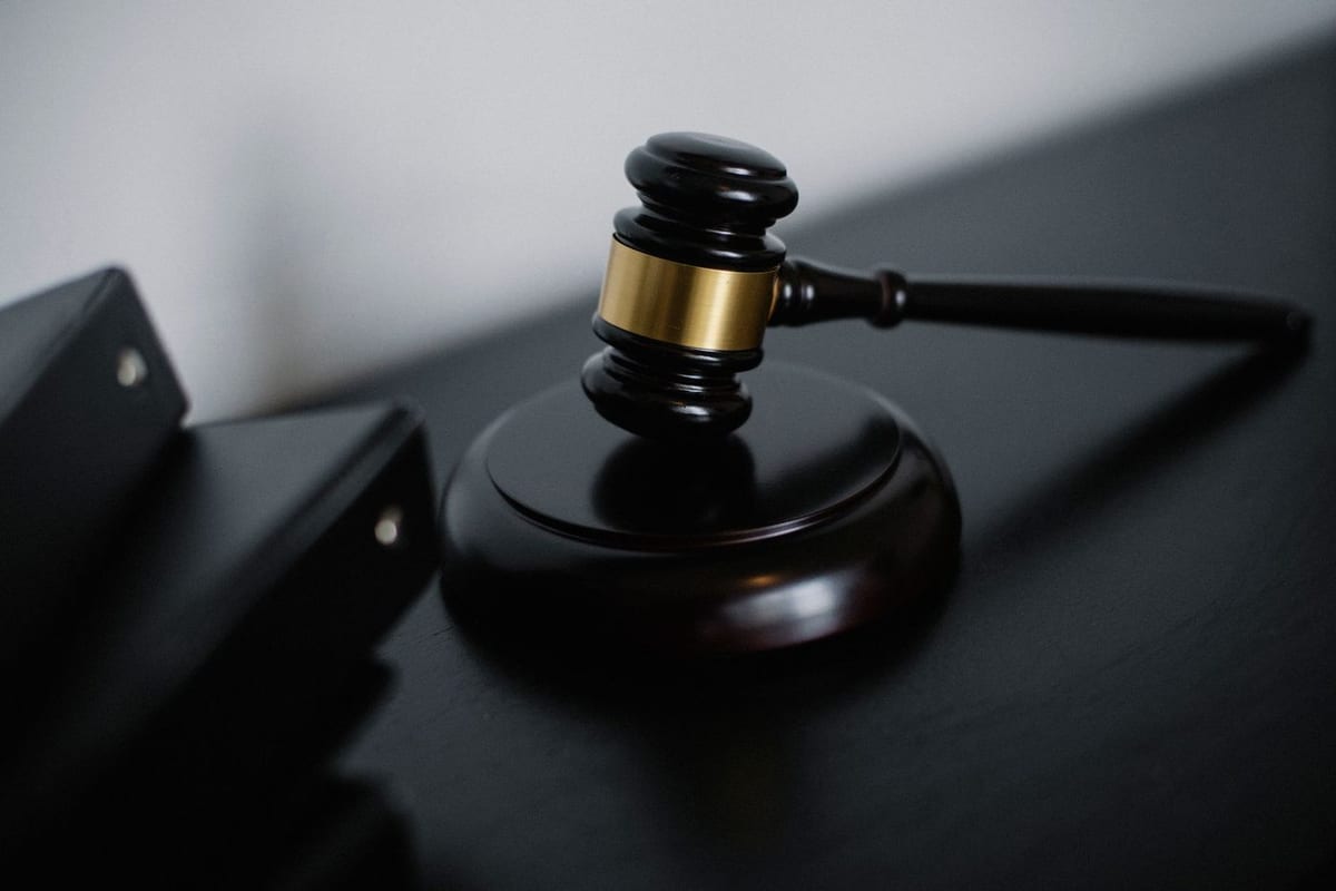 A gavel resting on a desk beside case folders